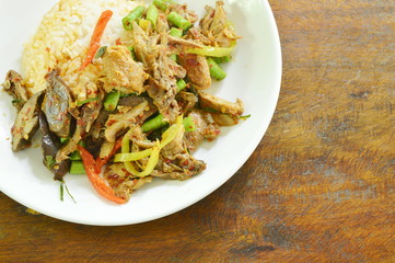 spicy fried duck meat curry with basil leaf and rice on plate