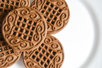 Chocolate cookies with cream filling on a white plate.