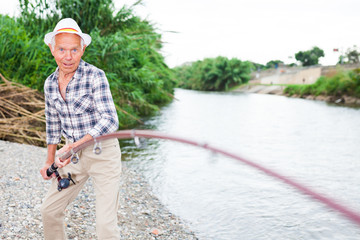 Aged fisherman pulling out catch