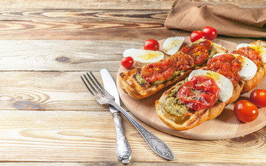 Bruschetta with baked tomatoes and mozzarella cheese. Mediterranean Kitchen. Tasty breakfast.