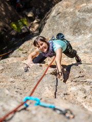 Beautiful smiling girl climbing on a rock crag in Majorca