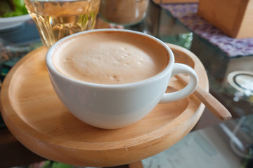 Coffee in a white cup and tea on the table.