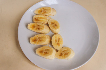 Pieces of banana on a plate. Candid.