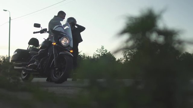 Couple on motorcycle stopped on road and quarreling