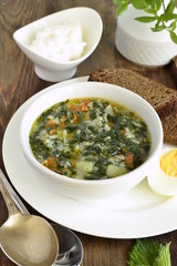 Nettle soup served with egg and sour cream