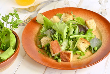 Fresh salad with lettuce, green peas, cucumber and croutons