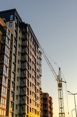 Fototapeta na wymiar Crane at a construction site in sunset light. Bottom view.