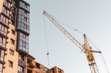 Crane at a construction site in sunset light. Bottom view.
