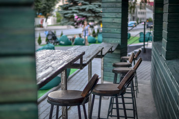 Long wooden chairs and green design. Selective focus.