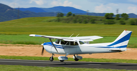 Naklejka na ściany i meble Sport airplane taking up from runway