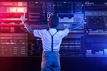 Hands on the screen. Calm clever progressive boy putting his hands up and touching the transparent screen while using a new program