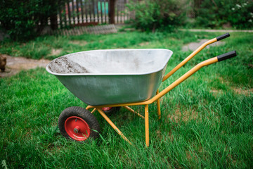 Work in the garden wheelbarrow on the front of the garden. Gardening tools: worn trolley 
