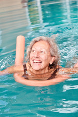 Vitale Senior Frau lernt schwimmen
