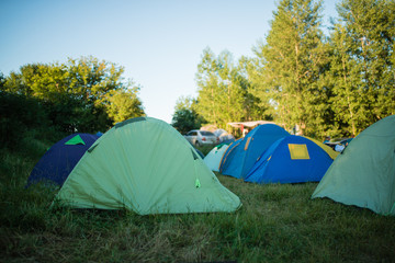 Camping in the clearing in the morning. Tents in the camping in the evening. recreation group of people