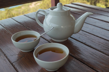 black tea in cups on a wooden table. tea-drinking with a view of the sea. 