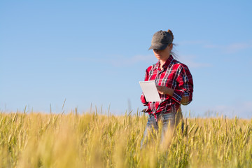 Girl farmer is in the field with a notebook in his hands.

