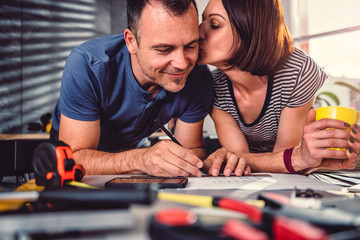 Wife kissing husband during kitchen renovation