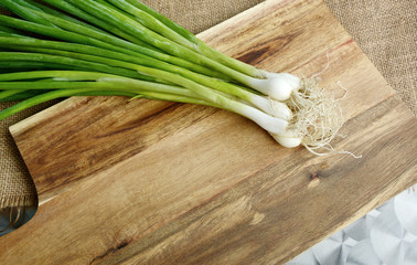 scallion,Spring onion or Green onion with root on wooden broad.