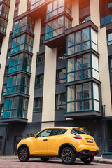 New multi-storey residential building with car parked in front. Modern house