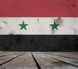 The floor of planks and plastered wall with a painted Syria flag. 