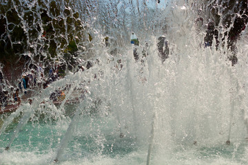 fountain in the summer in the park on the background of unrecognizable people