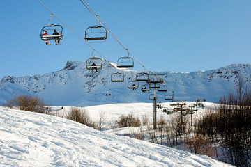 ski lift with tourists in mountains