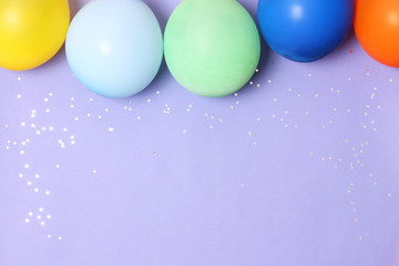 balloons, ribbons and confetti on a colored background top view. Celebration