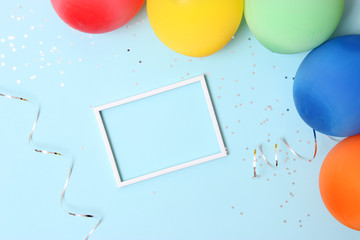 balloons, confetti, white frame and ribbons on a colored background top view. Celebration, birthday, celebrate, give. flatlay