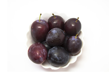 Plums in a vase on a white background isolated.