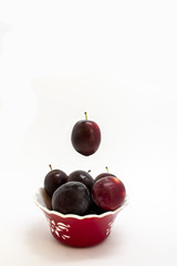 Plums in a vase on a white background isolated.