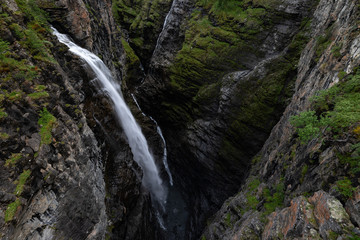 Fototapeta na wymiar Magnificent waterfall falls onto the bottom of the Gorsa canyon in Lyngenfjord, Norway.