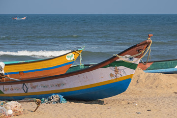 Part of the local fishing fleet stranded on the beach at Mamallapuram in Tamil Nadu, India. The main catches taken in the Bay of Bengal inshore fishery are pomfrets and prawns