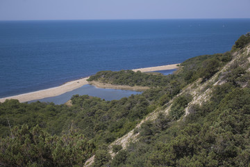 Summer landscape with mountains, azure water, sandy beach and blue sky in bright sunny day. Travel background.