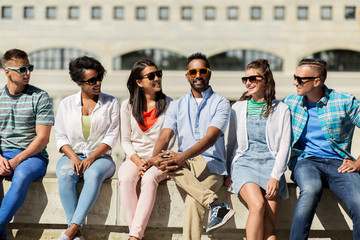 people, friendship and international concept - group of happy smiling friends in sunglasses in city