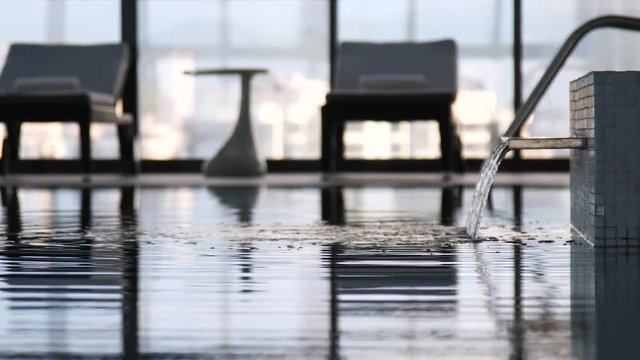 water flows from shower to pool. in the background window and view of the city