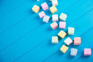 Pastel food set of colorful square marshmallow on vibrant blue background.