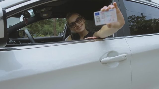 young happy woman showing her new driver license