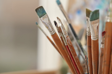 Paint brushes on blurred background, closeup