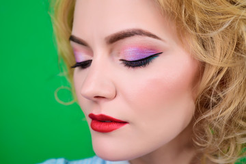 Close-up portrait of women's make-up in pin up style. Pin-up clothes. Portrait of beautiful blond pin up girl with red bandana. Woman with bright makeup. Retro style. Isolated on green background.