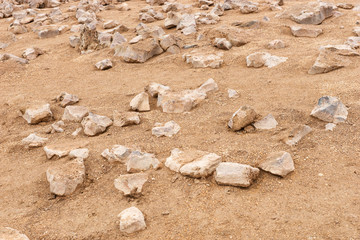 Pointed stones on sand. Sand and stone background