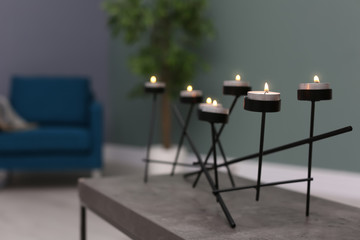 Burning candles on table indoors. Interior decor element
