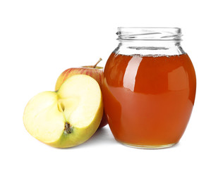 Glass jar with sweet honey and apples on white background