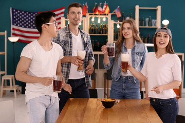 Friends with beer emotionally watching sports in bar