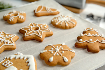 Fototapeta na wymiar Tasty decorated Christmas cookies on baking parchment