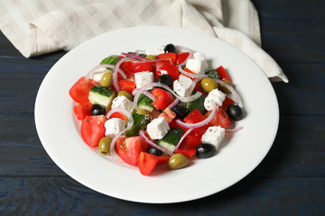 Plate with delicious fresh salad on table
