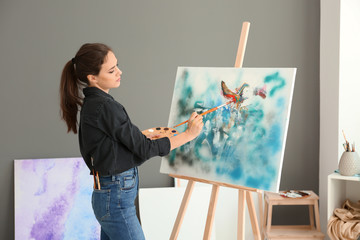 Female artist painting picture in workshop