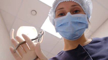 Dentist bends over the patient and treats the teeth. On reception at the doctor of the stomatologist