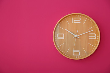 Stylish clock on color wall. Time concept