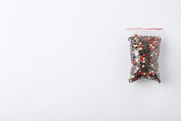 Plastic bag with spice on white background, top view