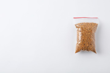 Plastic bag with spice on white background, top view